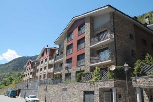 a brick building with balconies on the side of a street at Genciana Estudio en el Tarter, zona Grandvalira in El Tarter