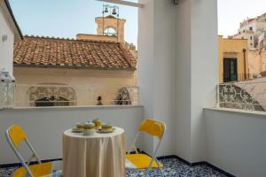 a table and chairs on a balcony with a building at Dolce Pausa in Atrani