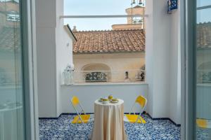 a table and chairs in a room with a window at Dolce Pausa in Atrani