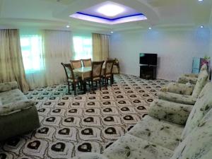 a living room with a table and chairs at Asson Hotel Termez in Termiz