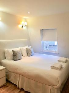 a bedroom with a large white bed with a window at The Paramount Hotel in London