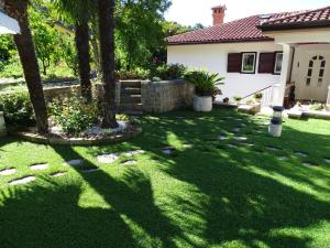 un patio con césped verde y árboles y una casa en Villa Lili, en Portorož