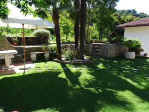 un patio con árboles y una sombrilla blanca en Villa Lili, en Portorož