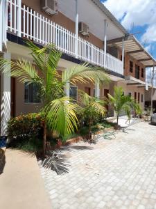 a building with palm trees in front of it at Hotel Rio Araguaia Xambioá TO in Xambioá