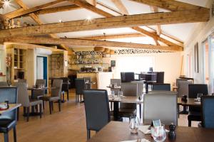 un ristorante con soffitti e tavoli in legno e sedie di Kyriad Montpellier Sud - A709 a Montpellier