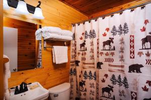 a bathroom with a shower curtain with animals on it at Cobble Mountain Lodge in Lake Placid