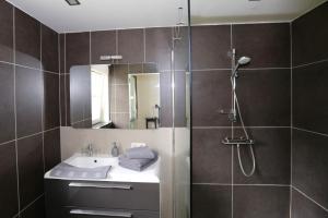 a bathroom with a sink and a shower at B&B Le Bois de Champia in Huy