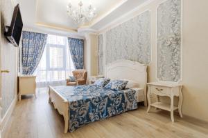 Schlafzimmer mit einem Bett und einem Kronleuchter in der Unterkunft Barkar ArCadia Apartments in Odessa