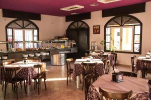 a restaurant with tables and chairs and a kitchen at Hotel Agades in San José