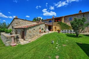 an external view of a stone house with a yard at Villa Sonia by PosarelliVillas in San Donato in Poggio