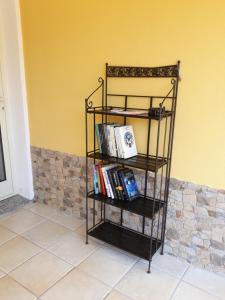 a book shelf with books on it next to a wall at Bentus B&B in Villasimius