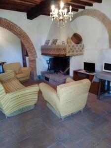 sala de estar con 2 sillas y chimenea en Agriturismo Stigliano en Sarteano