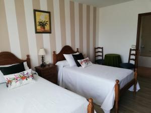 two beds in a room with striped walls at A Casa De Amparo in Sanxenxo +15 photos