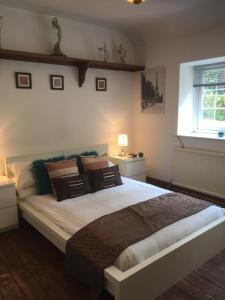 a bedroom with a large bed and a window at Scaurbridge Cottage with Hot Tub and Sauna in Thornhill