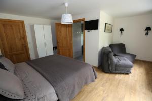 ein Schlafzimmer mit einem Bett und einem Stuhl in der Unterkunft B&B Le Bois de Champia in Huy