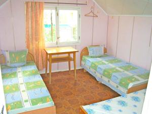 Habitación con 2 camas, mesa y ventana en Adore, en Sudak