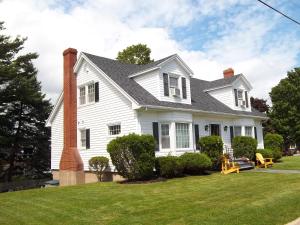 a white house with a chimney and a lawn at Abide Within Bed & Breakfast in Truro