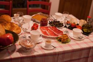 una mesa llena de comida, copas de vino y carne en Casas Rural Calaceite, en Calaceite