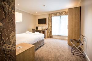 Habitación de hotel con cama y ventana en The Residence Hotel at The Nottinghamshire Golf & Country Club en Nottingham