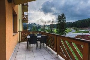 a balcony with a table and chairs on it at Apartmán Tatran Donovaly Deluxe in Donovaly