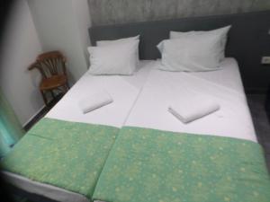 un letto con piumone verde e bianco e una sedia di Nafsika Hotel Athens Centre ad Atene