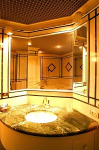 uma casa de banho com um lavatório e um espelho grande em Hotel&Ristorante Miramonti Palazzo Storico em Rieti