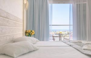 a bedroom with a bed with a window and a table at Samos Sun in Pythagoreio