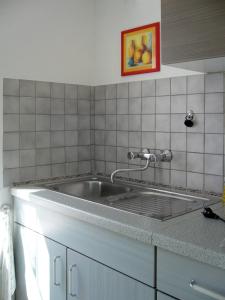 - une cuisine avec un évier et un mur en carrelage dans l'établissement Haus Gieselsberg, mit Aussicht auf Schmalkalden, à Schmalkalden