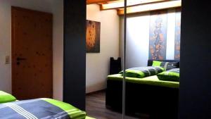 um quarto com 2 camas e almofadas verdes em Haus Fliegerhorst em Königschaffhausen
