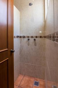 a bathroom with a walk in shower next to a door at Hotel del Marquesado in Oaxaca City