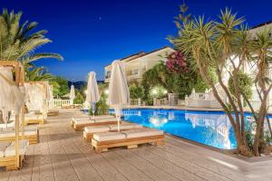 a resort pool with lounge chairs and umbrellas at Samos Sun in Pythagoreio +17 photos