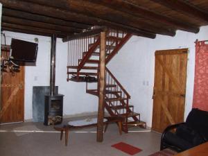 a wooden spiral staircase in a living room with a fireplace at Cabañas Wenelcklén in Uspallata