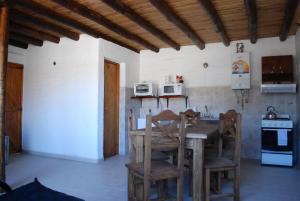 a kitchen with a wooden table and chairs at Cabañas Wenelcklén in Uspallata