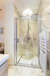 パリにあるCMG Saint Germain / Jardin du Luxembourg IIの大理石の壁のバスルーム(シャワー付)が備わります。