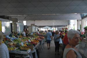 un groupe de personnes qui traversent un marché de fruits et légumes dans l'établissement Torre Scola, à La Spezia