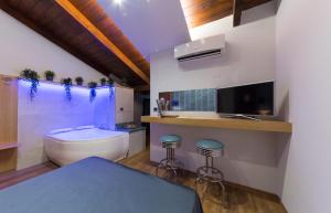 ein Badezimmer mit einer Badewanne, einem TV und einer Badewanne in der Unterkunft Hotel Vogue in Licola