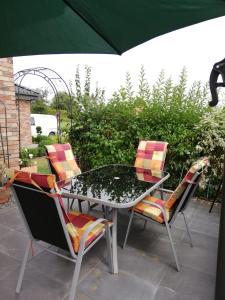 een terrastafel en stoelen met een parasol bij Apartment Hasselstrasse in Mehren