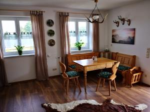 a dining room with a table and chairs and windows at Jägerstüble in Altusried