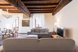 a living room with a couch and a television at Palazzo Del Pero Luxury Attic - byMyHomeinComo in Como