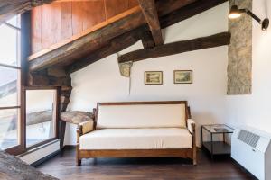 a room with a bench in a room with wooden ceilings at Palazzo Del Pero Luxury Attic - byMyHomeinComo in Como