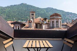 a bench on top of a building with a mountain at Palazzo Del Pero Luxury Attic - byMyHomeinComo in Como