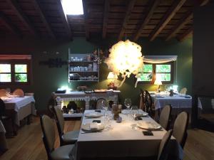 a restaurant with white tables and chairs and a chandelier at Posada Real Torre Berrueza in Espinosa de los Monteros