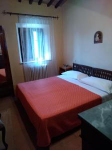 a bedroom with a large bed with a red blanket at Agriturismo Stigliano in Sarteano