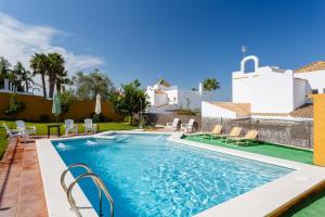 basen z krzesłami i dom w tle w obiekcie Bonito Chalet Con Vistas w mieście Sanlúcar de Barrameda