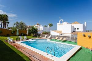 una piscina en el patio trasero de una villa en Bonito Chalet Con Vistas en Sanlúcar de Barrameda
