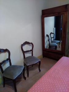 サルテアーノにあるAgriturismo Stiglianoの椅子2脚と鏡付きの部屋
