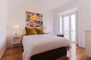 リスボンにあるTypical Mouraria by Homingの白いベッドルーム(大型ベッド1台、窓付)