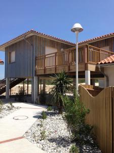 a house with a wooden deck and a fence at Residence Plage Oceane in Biscarrosse-Plage