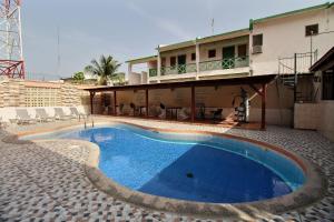 a swimming pool in front of a building at Hotel Garant & Suites in Boca Chica