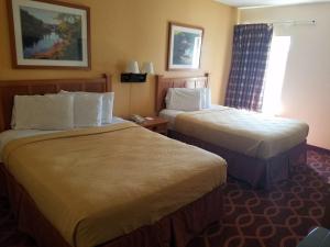 a hotel room with two beds and a window at Americas Best Value Inn Evansville East in Evansville
